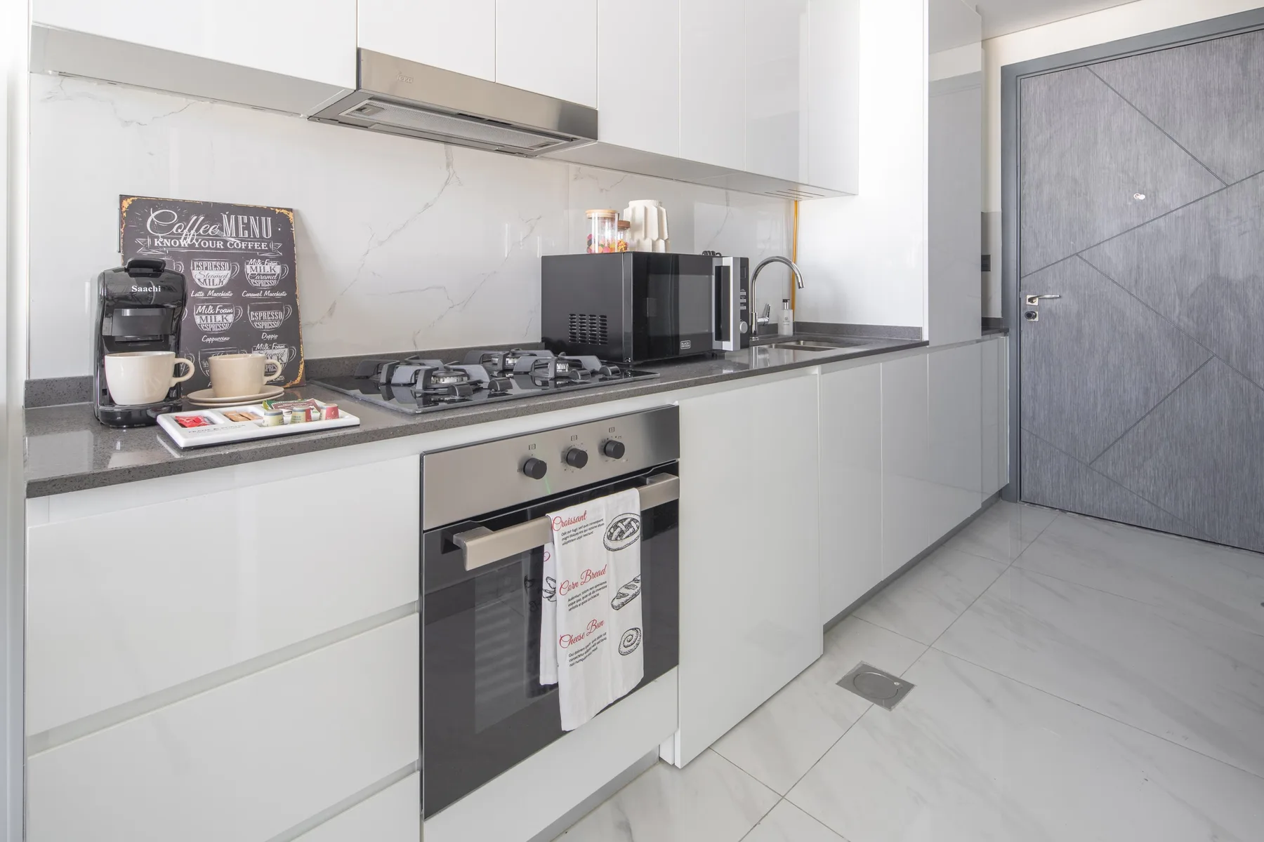 Una cocina moderna con gabinetes blancos, una estufa y un horno.
