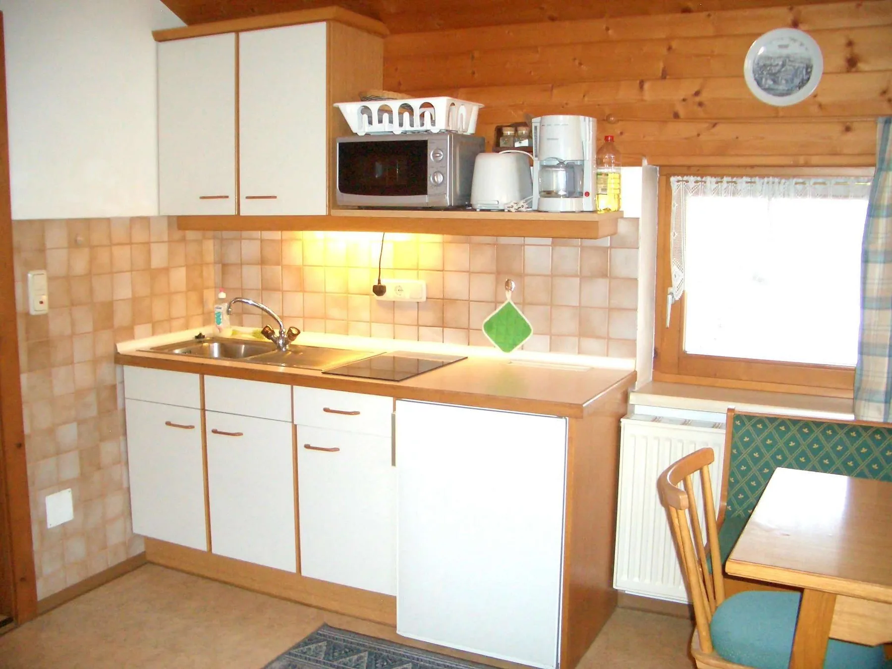 A compact kitchen with a countertop, sink, and small appliances.