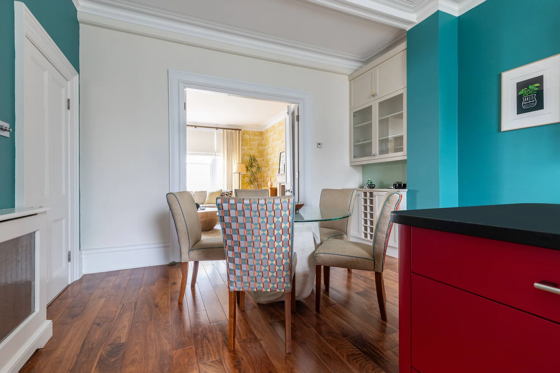 A dining area with a glass table and upholstered seating.