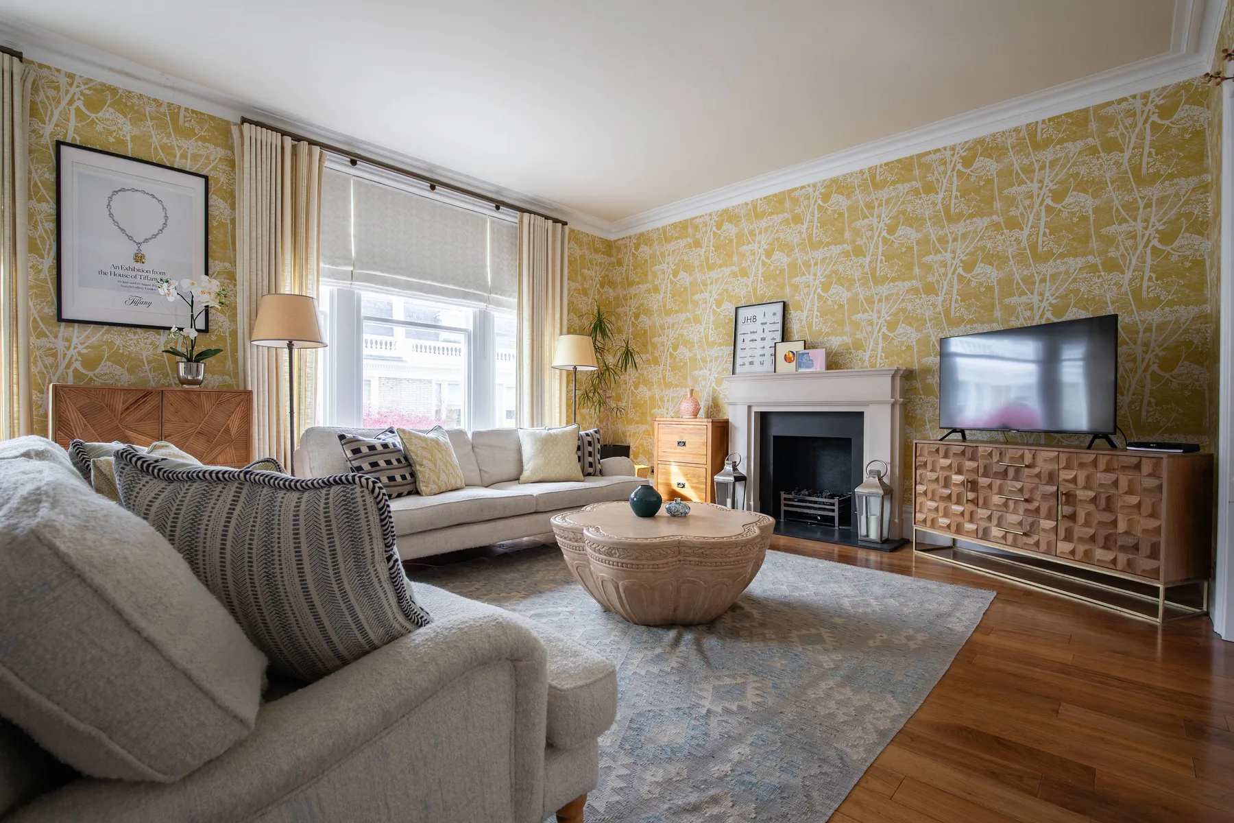 A living room with seating, a fireplace, and a television.