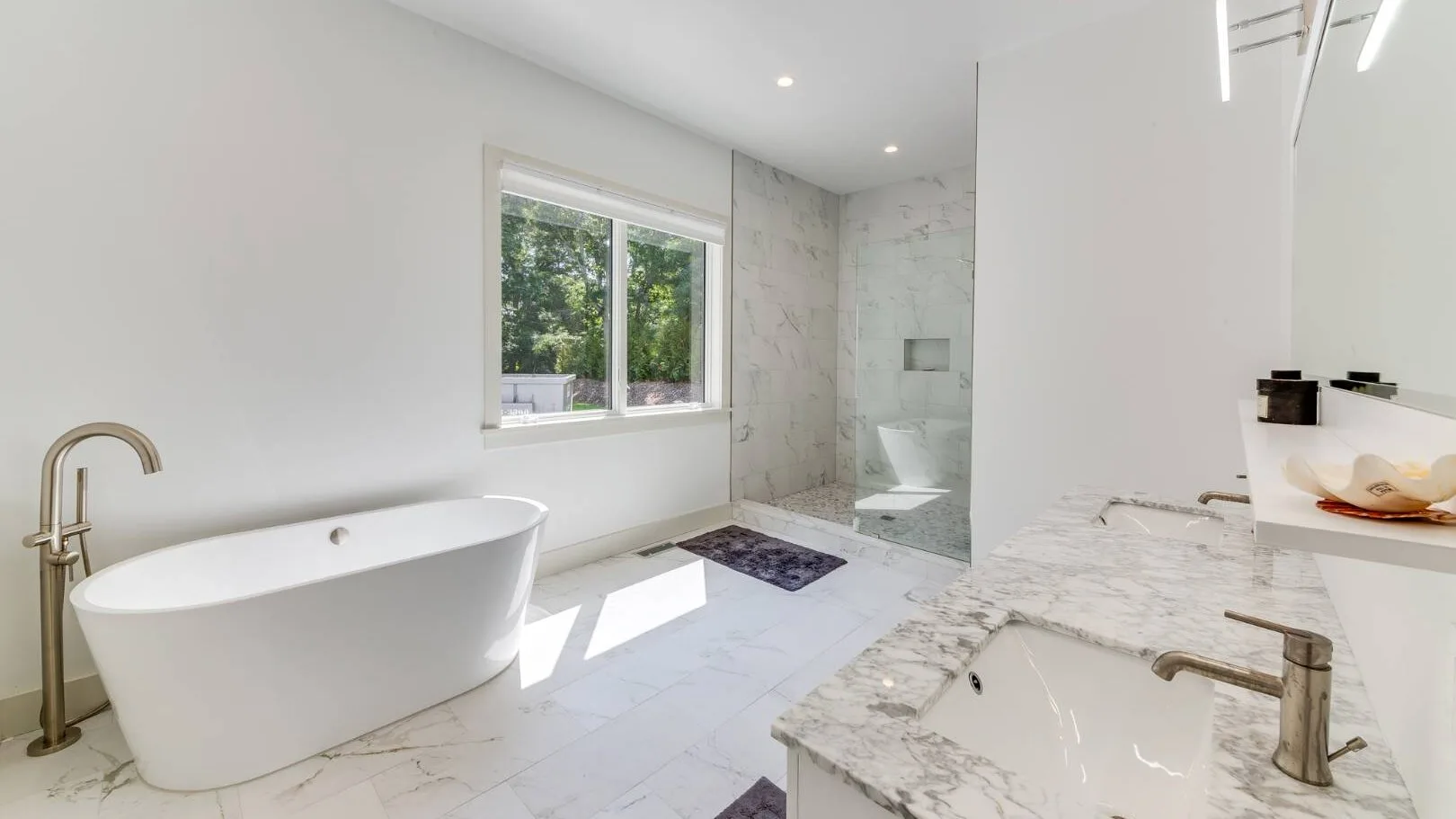 Un baño luminoso con bañera exenta, ducha y ventana.
