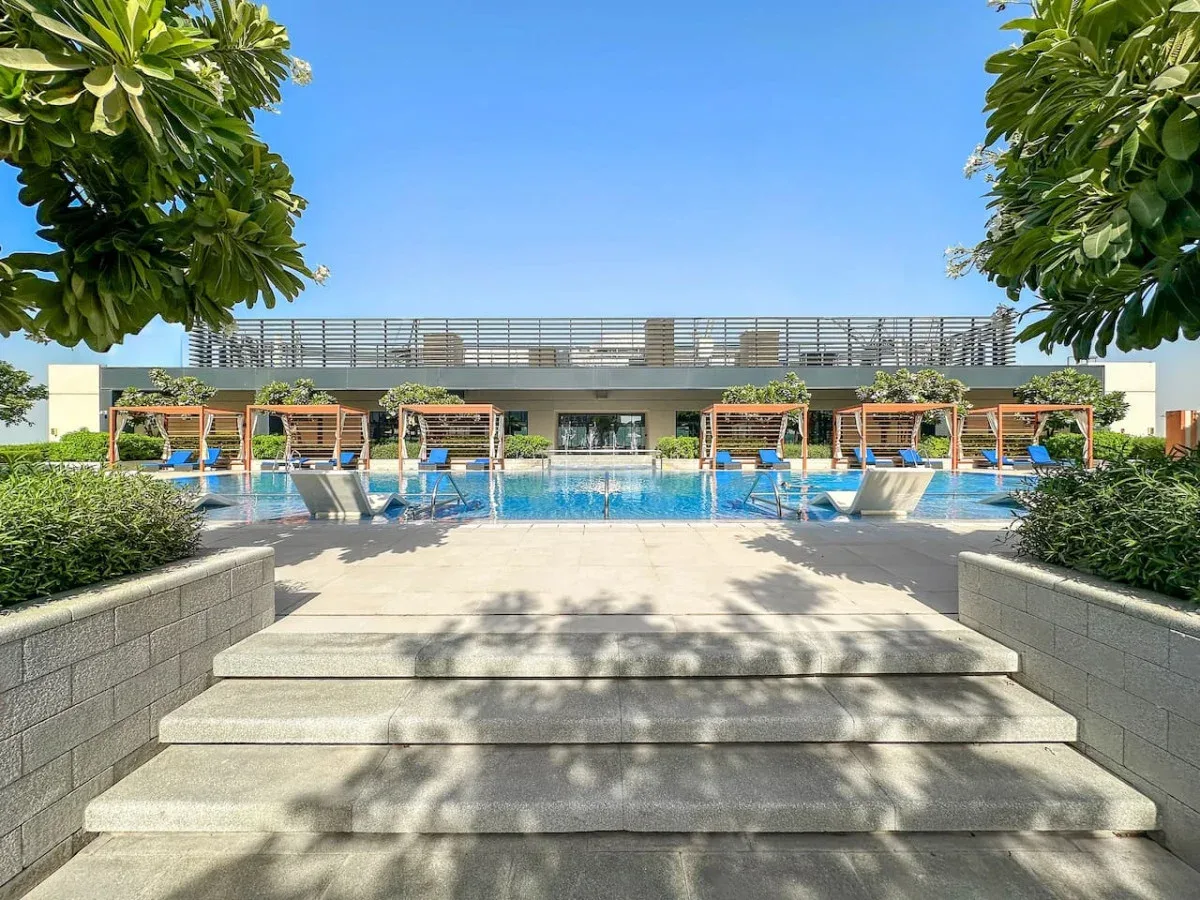 Una piscina al aire libre con asientos y árboles.