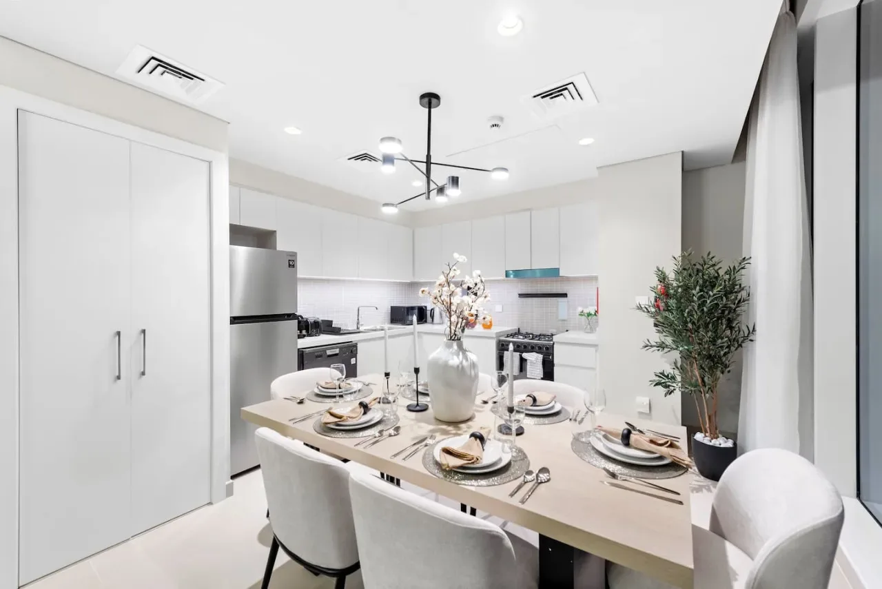 A bright kitchen and dining area with a table set for a meal.