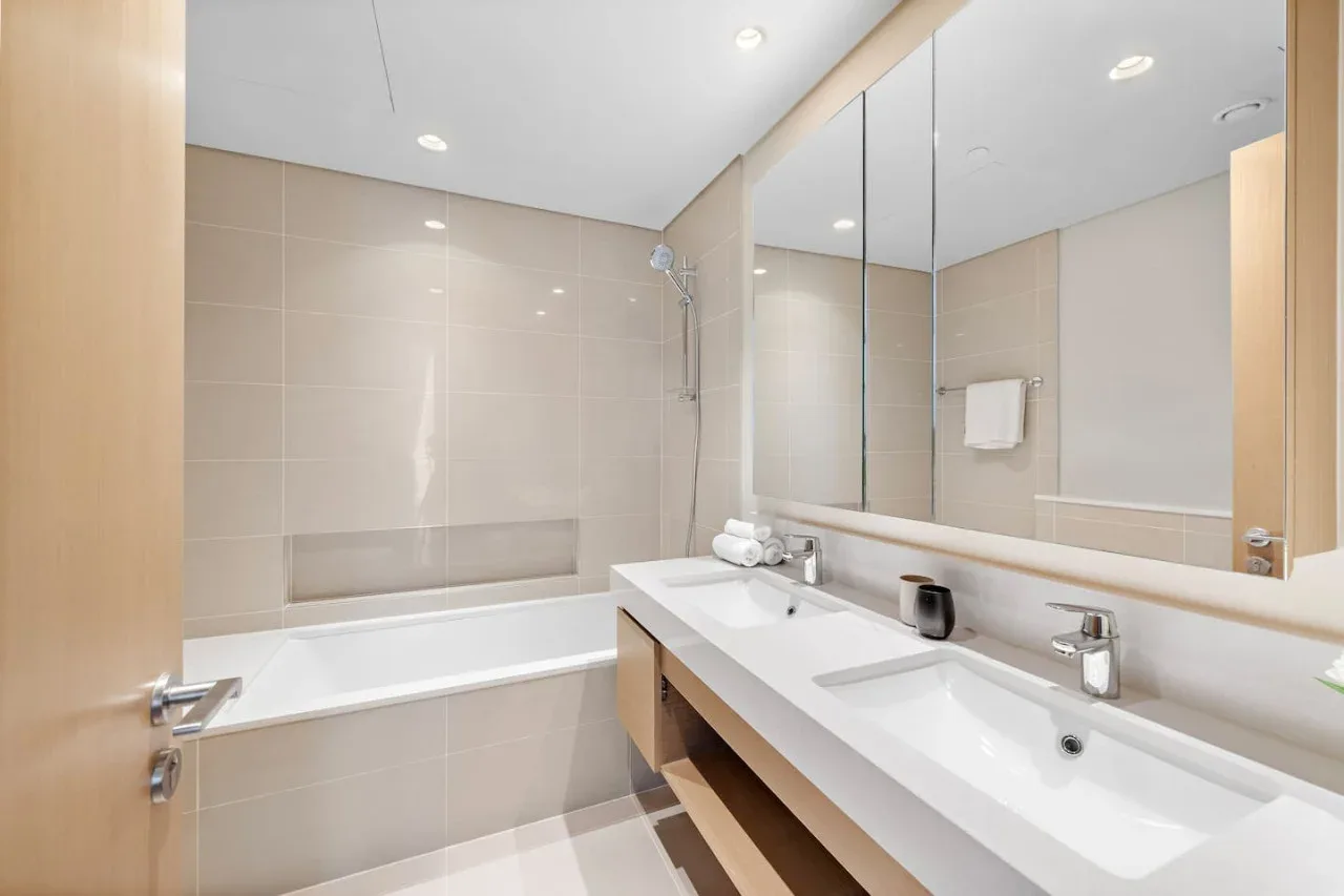 Un baño luminoso con bañera y un largo tocador.