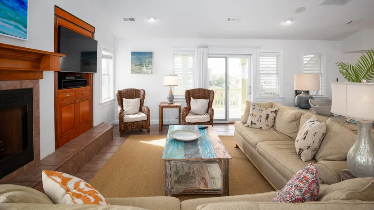 A bright living room with seating around a coffee table and a fireplace.