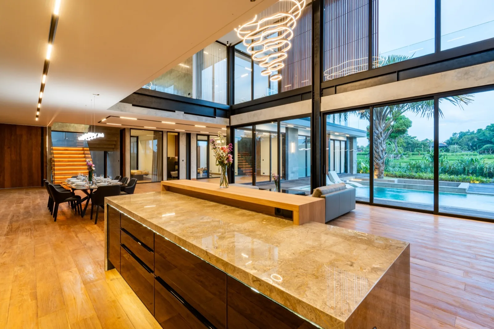 A spacious open-plan living and dining area features a kitchen island and large windows.
