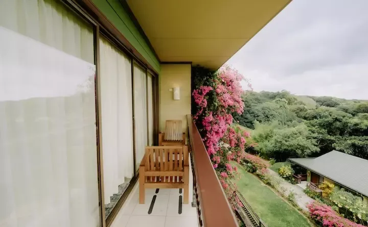Balcón de la habitación con cama king y vista a la montaña