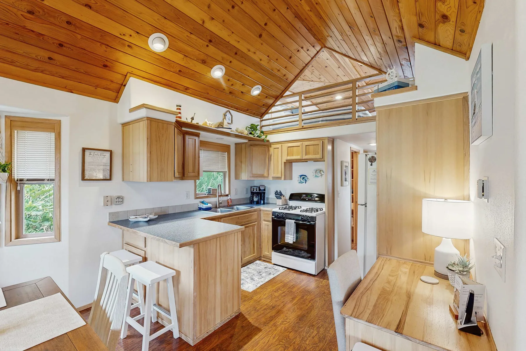 Una cocina compacta con una isla de madera bajo un techo inclinado de madera.
