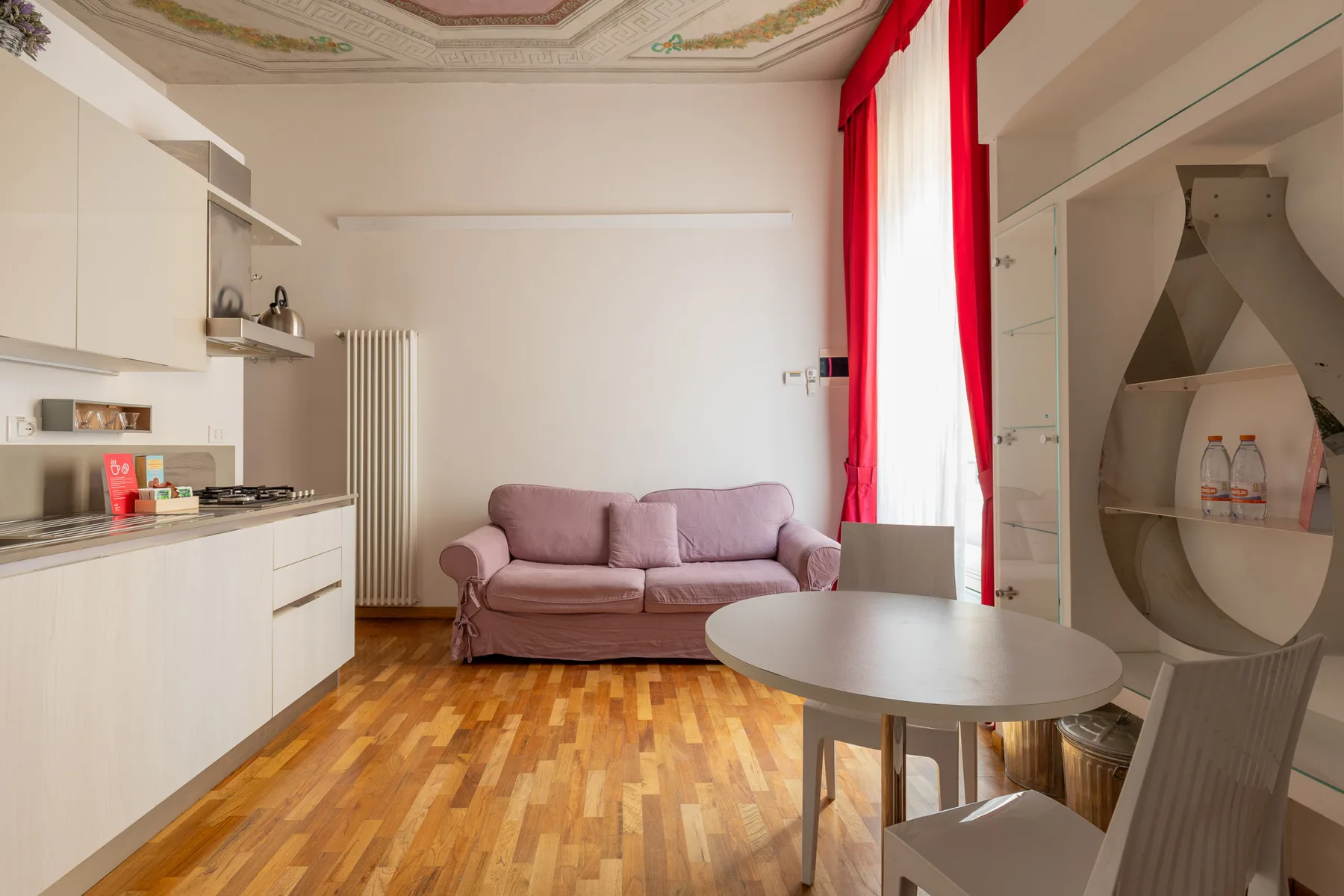 Una sala de estar con sofá, mesa de comedor y encimera de cocina.