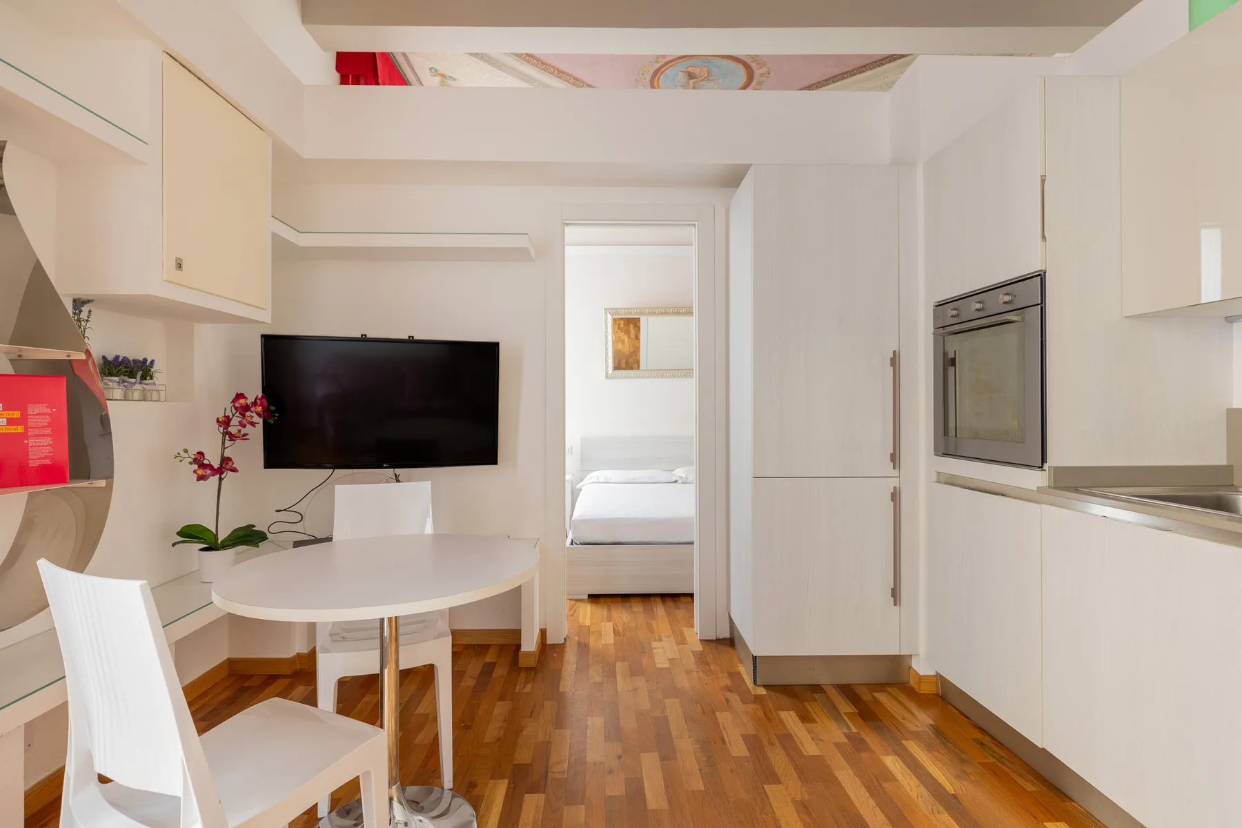 Una cocina y comedor luminosos se abren a un dormitorio a través de una puerta.