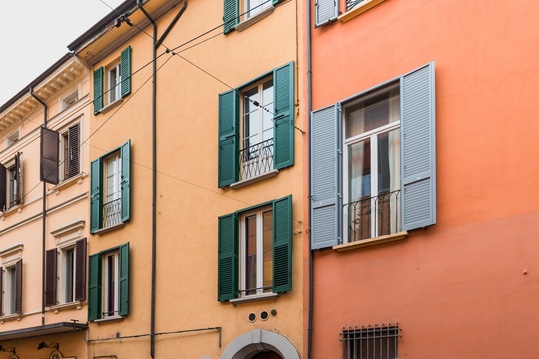 Una hilera de fachadas coloridas con ventanas y contraventanas.