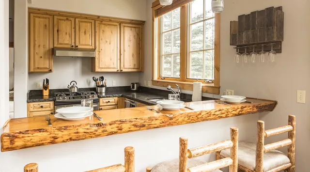 Una cocina con gabinetes de madera y una encimera de piedra.