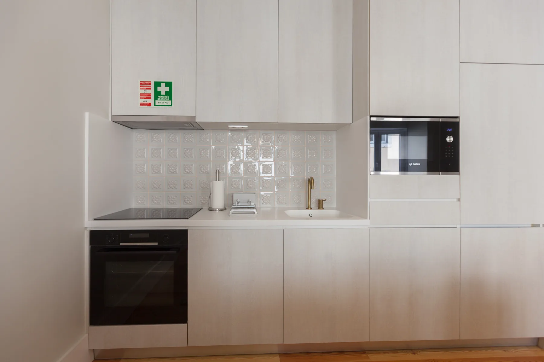 Una cocina moderna con electrodomésticos integrados y un salpicadero de azulejos claros.