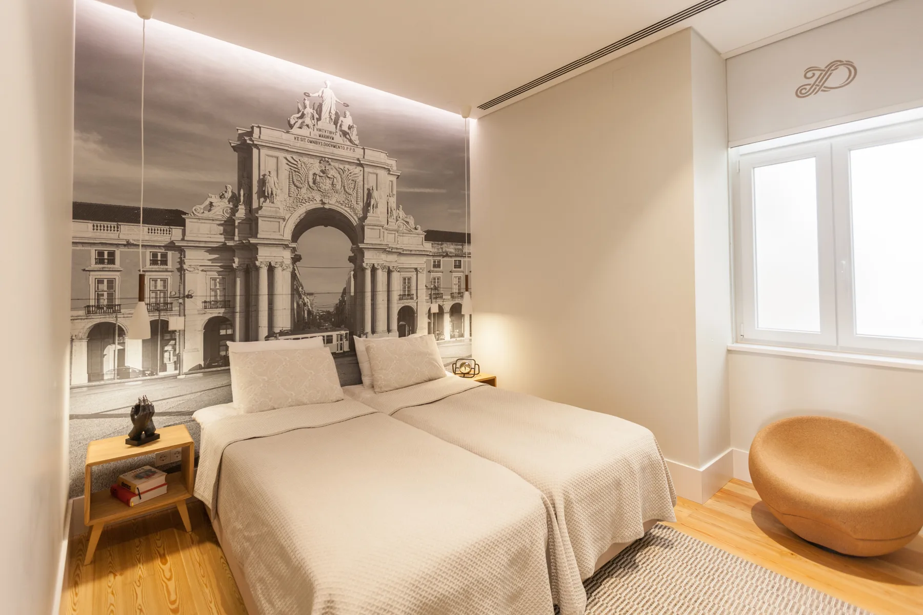 A bedroom with two beds beneath a large architectural wall mural.