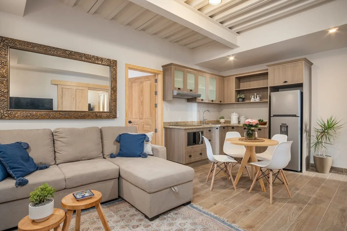 A living room opens into a kitchen and dining area, with a sectional sofa.
