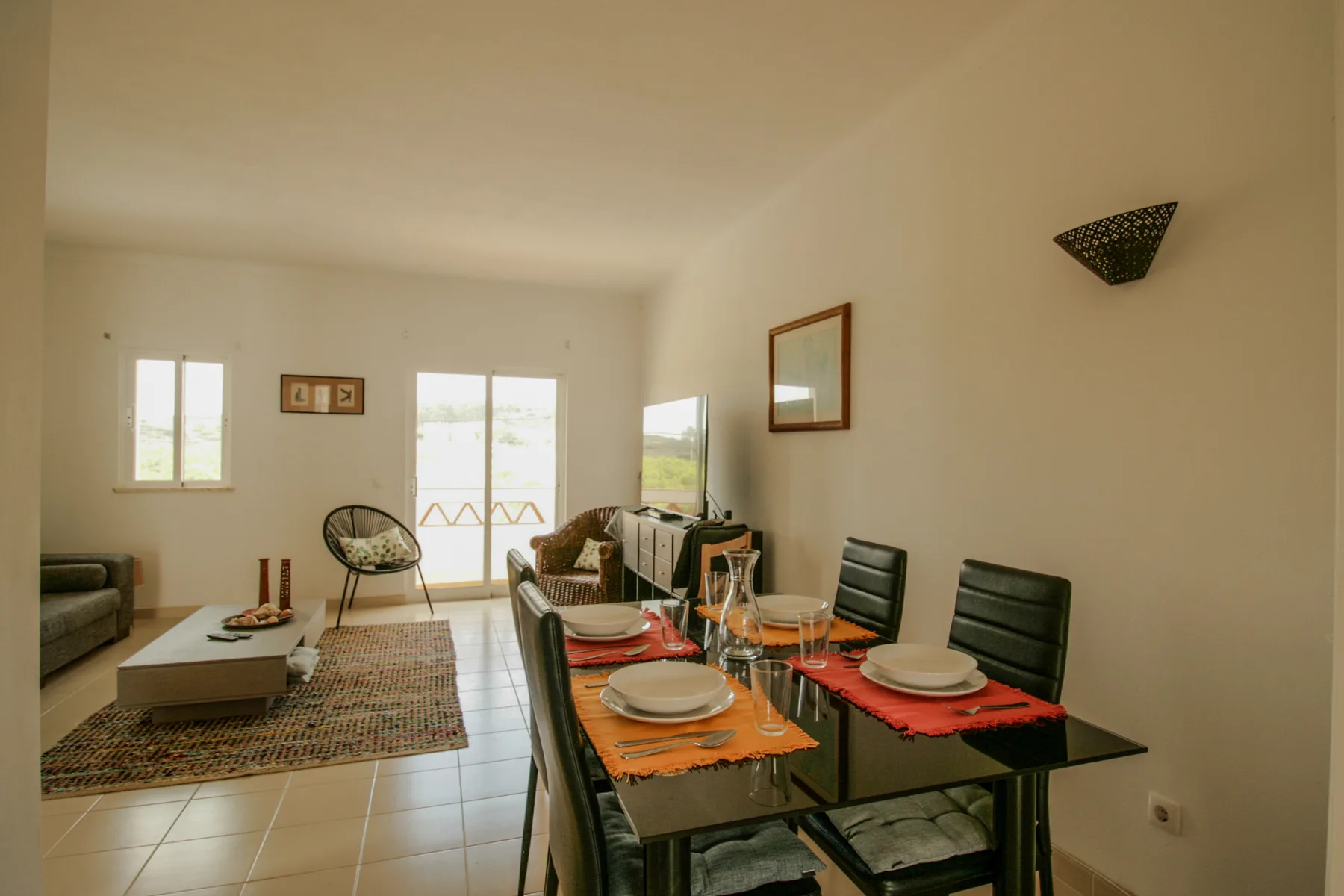 A living and dining room with a set dining table and seating area.