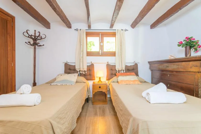 A bedroom with two beds and a small table between them.