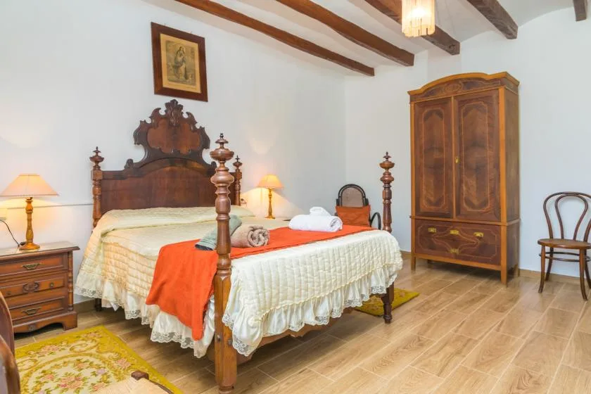 A bedroom with a wooden bed, bedside tables, and a wardrobe.