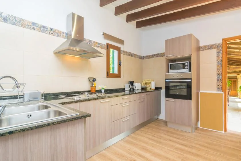 A kitchen with wood-toned cabinets, a cooktop, and built-in appliances.
