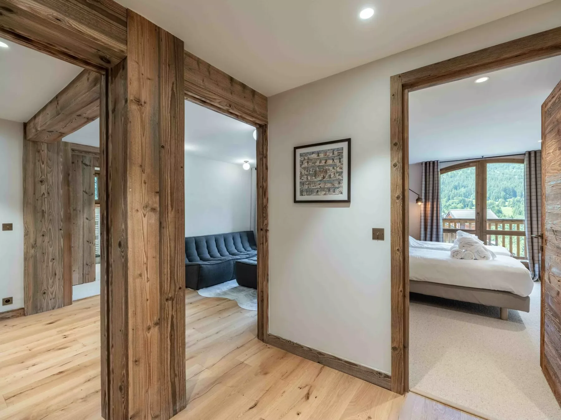 A wood-trimmed interior hallway opens onto a sitting area and bedroom.