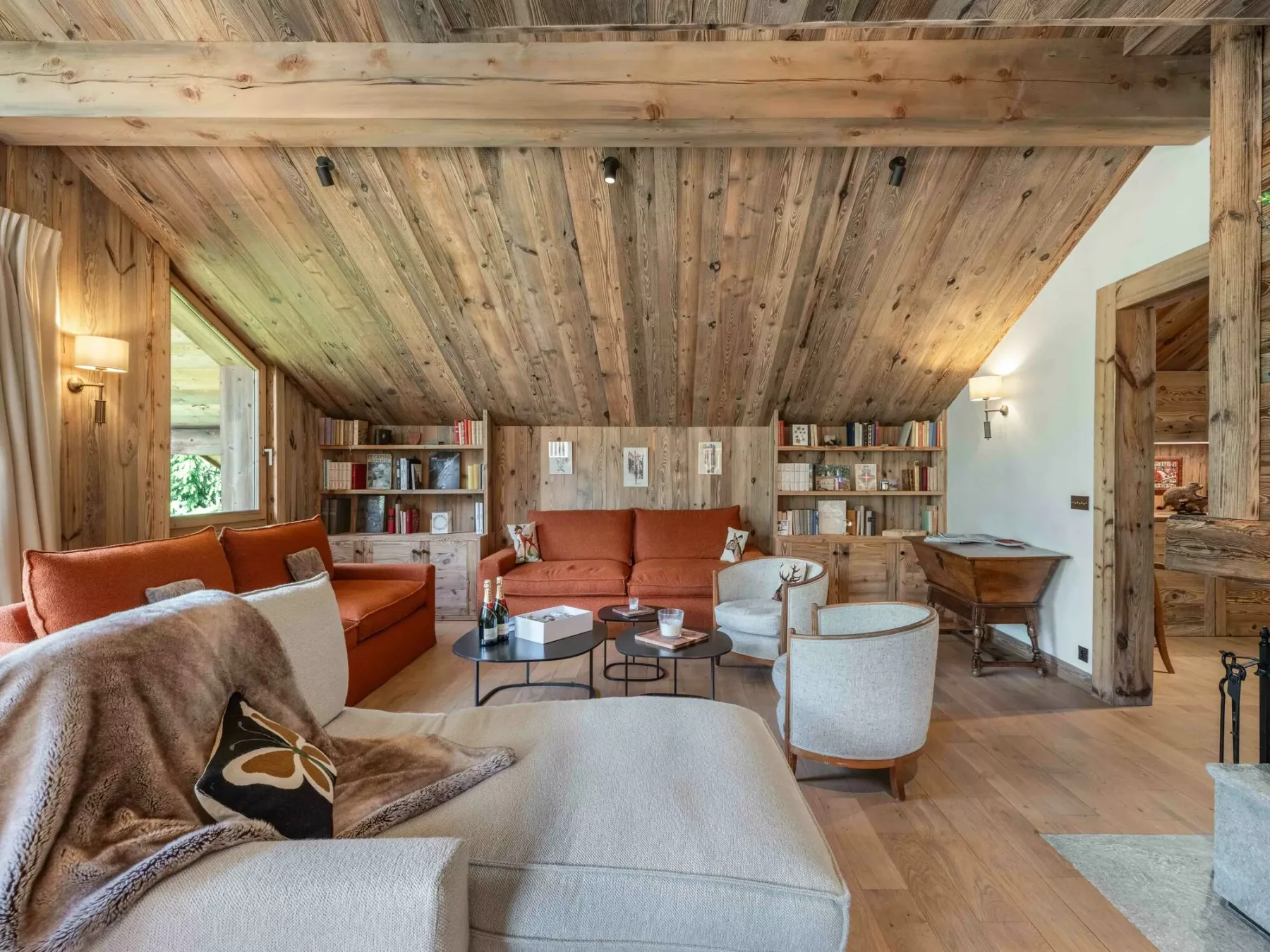 Sala de estar revestida de madera, con asientos y estanterías.
