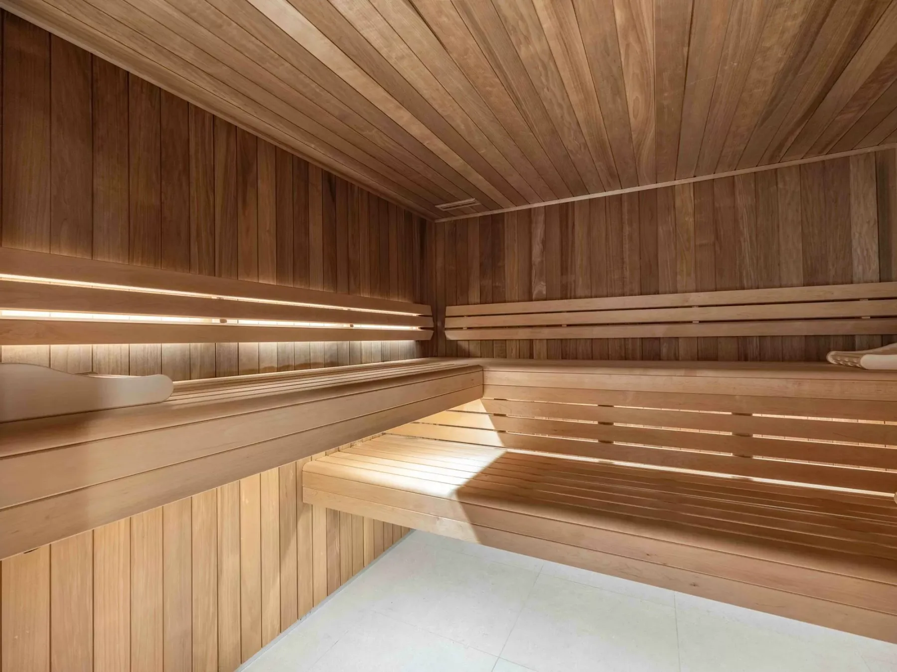 A wood-paneled sauna room with tiered wooden seating.