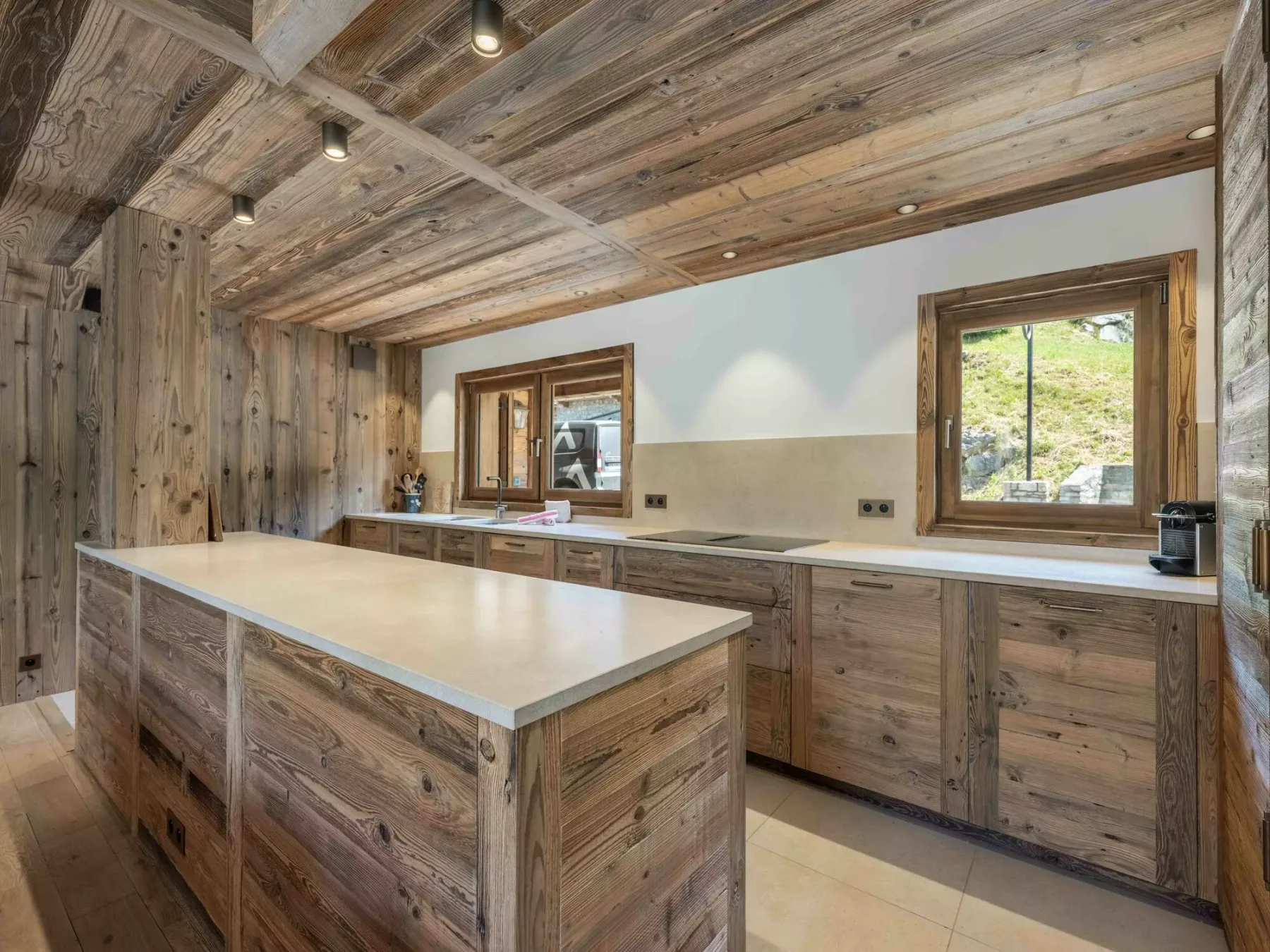 A rustic kitchen with a large central island and wooden cabinetry.