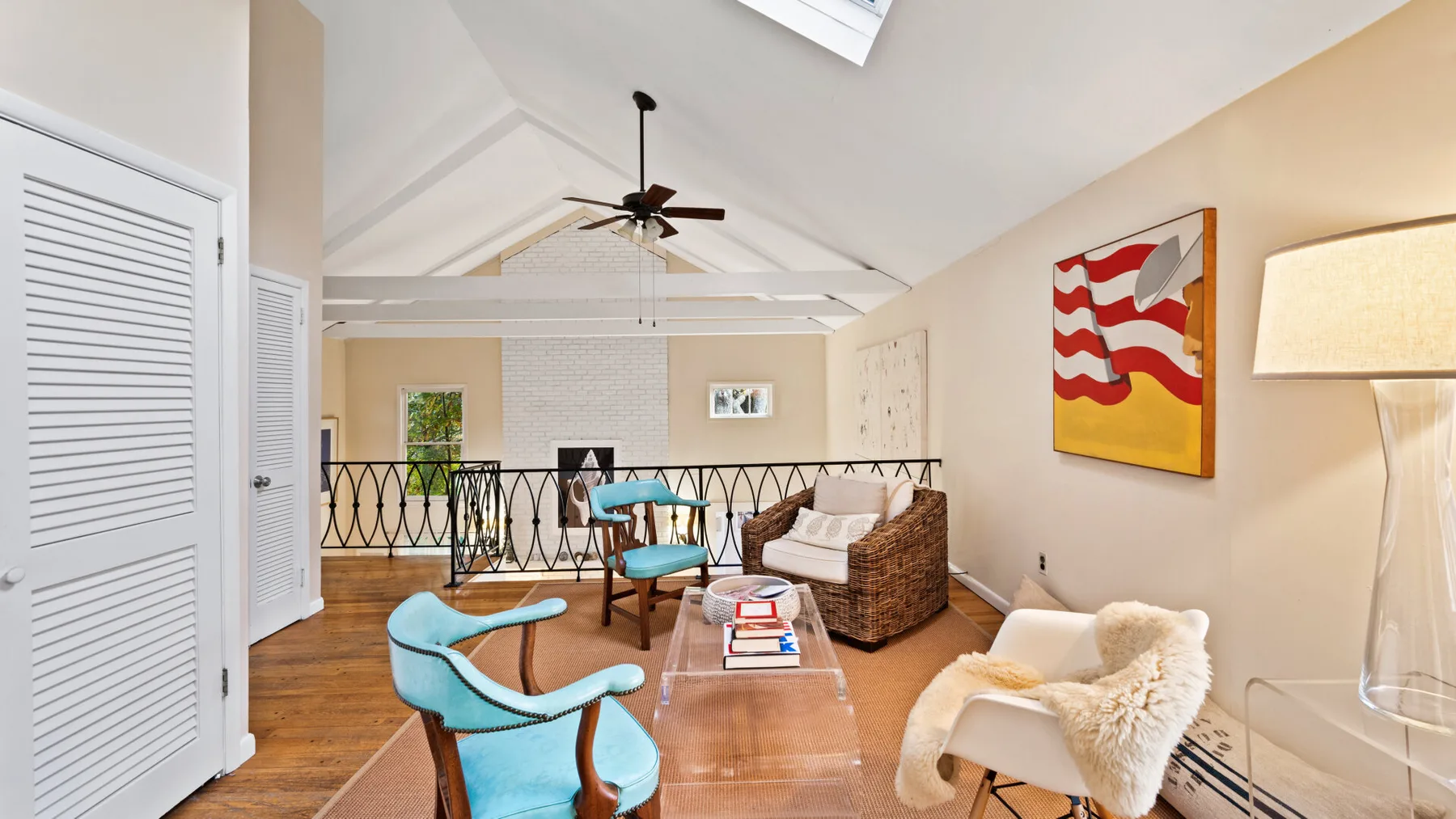 A bright living area with seating, a coffee table, and a high sloped ceiling.