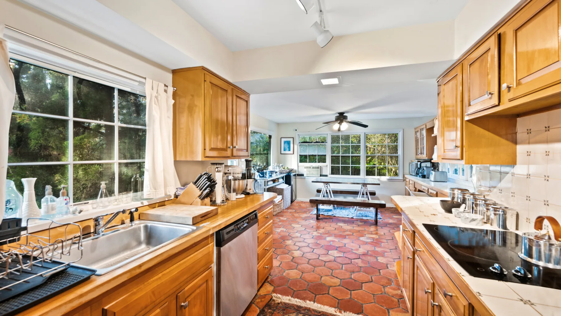 A kitchen with wooden cabinets and a long central dining table.