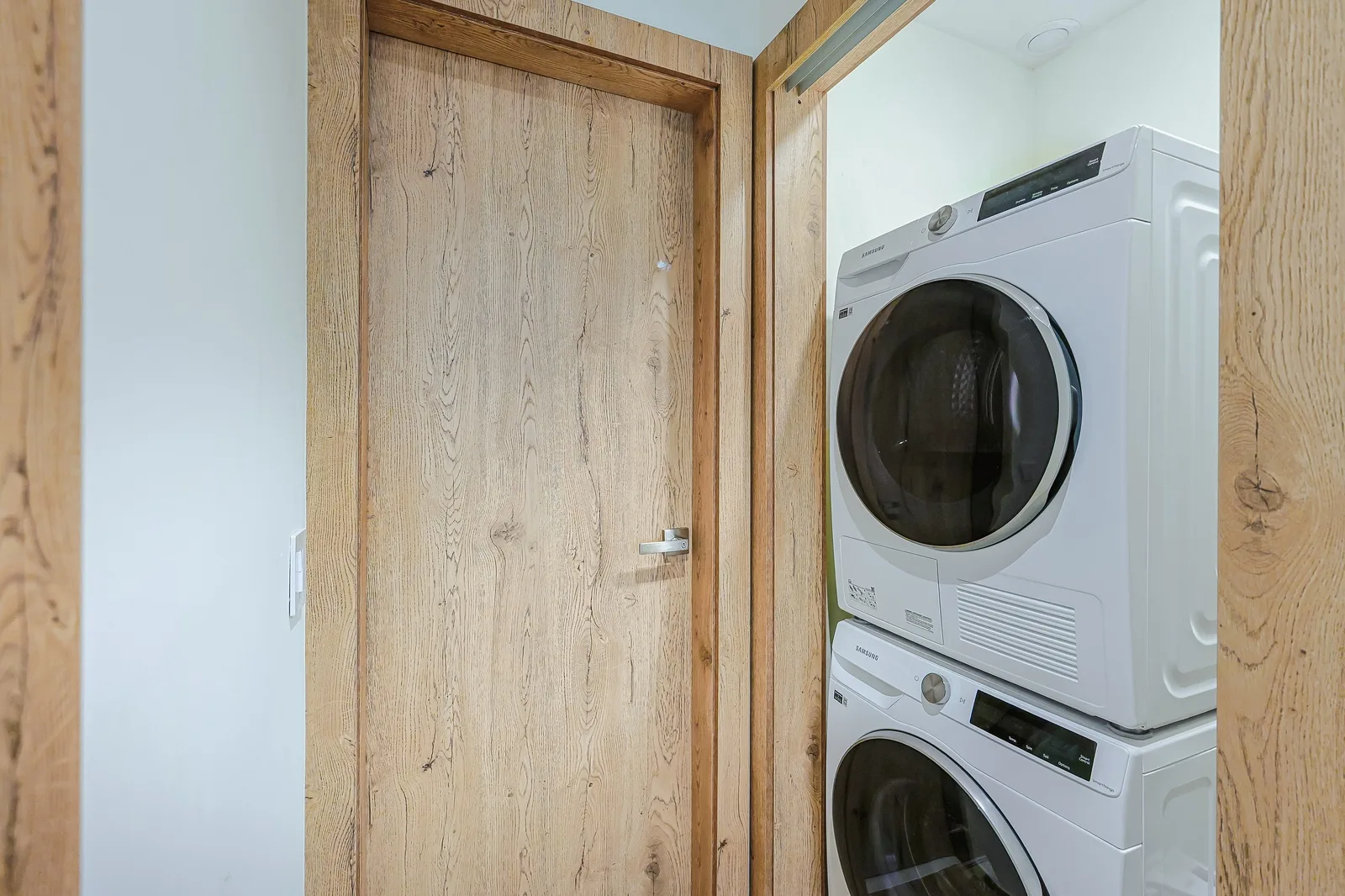 Your dedicated laundry nook makes it easy to pack light—washer and dryer stacked neatly in a clean, private alcove with natural wood accents.