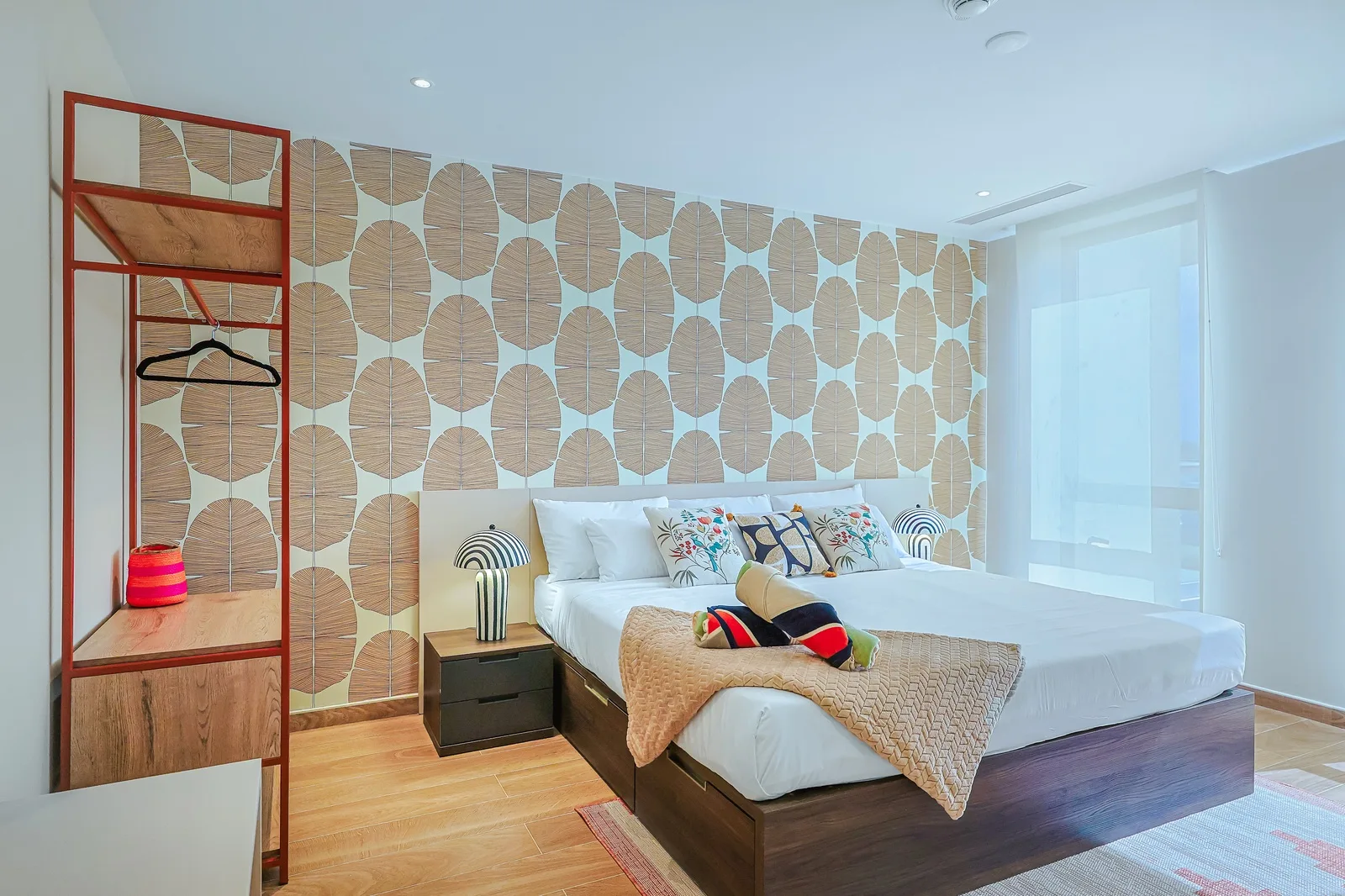Sink into crisp white linens beneath a striking woven wall feature. Your bedroom blends modern comfort with artisan warmth, ready for restful nights.