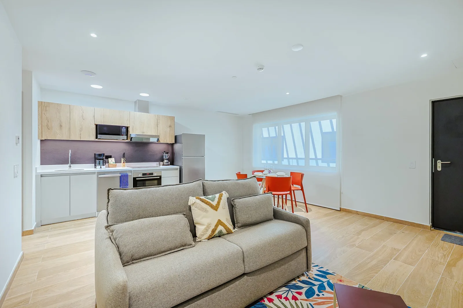 Unwind in your bright, open-concept living space where a cozy sofa invites you to relax. The fully equipped kitchen and cheerful dining nook make it easy to feel right at home.
