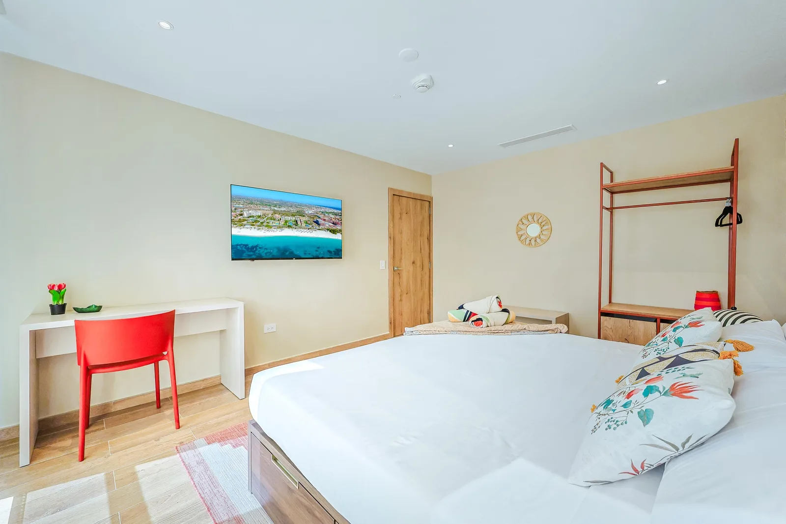 Step into your bright, serene bedroom where modern design meets warm, inviting tones. Sink into crisp linens and let that playful pop of red energize your mornings—your perfect home base awaits.