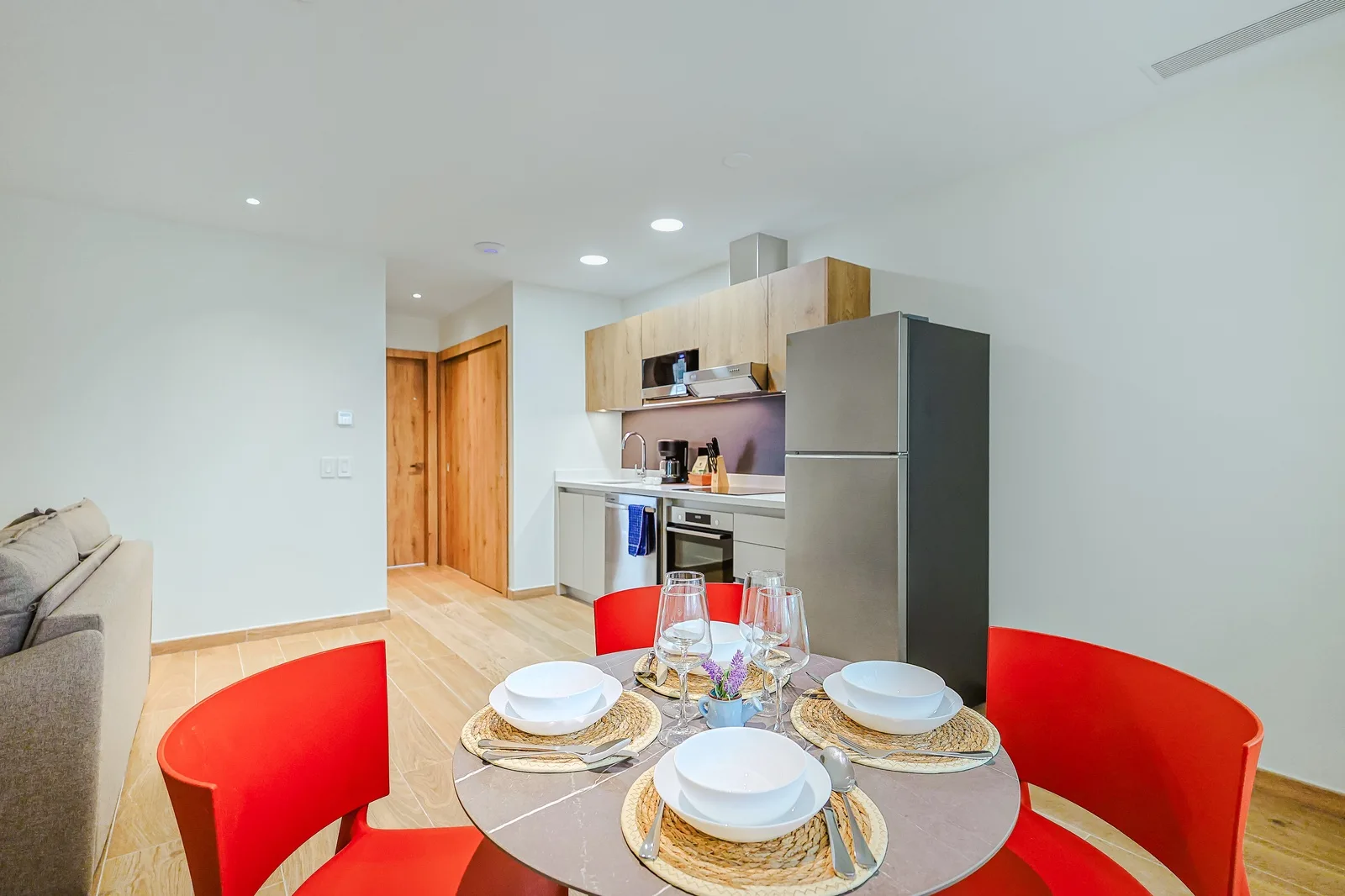 Gather around the sleek dining table set for four, with your bright modern kitchen just steps away—everything you need for effortless meals at home.