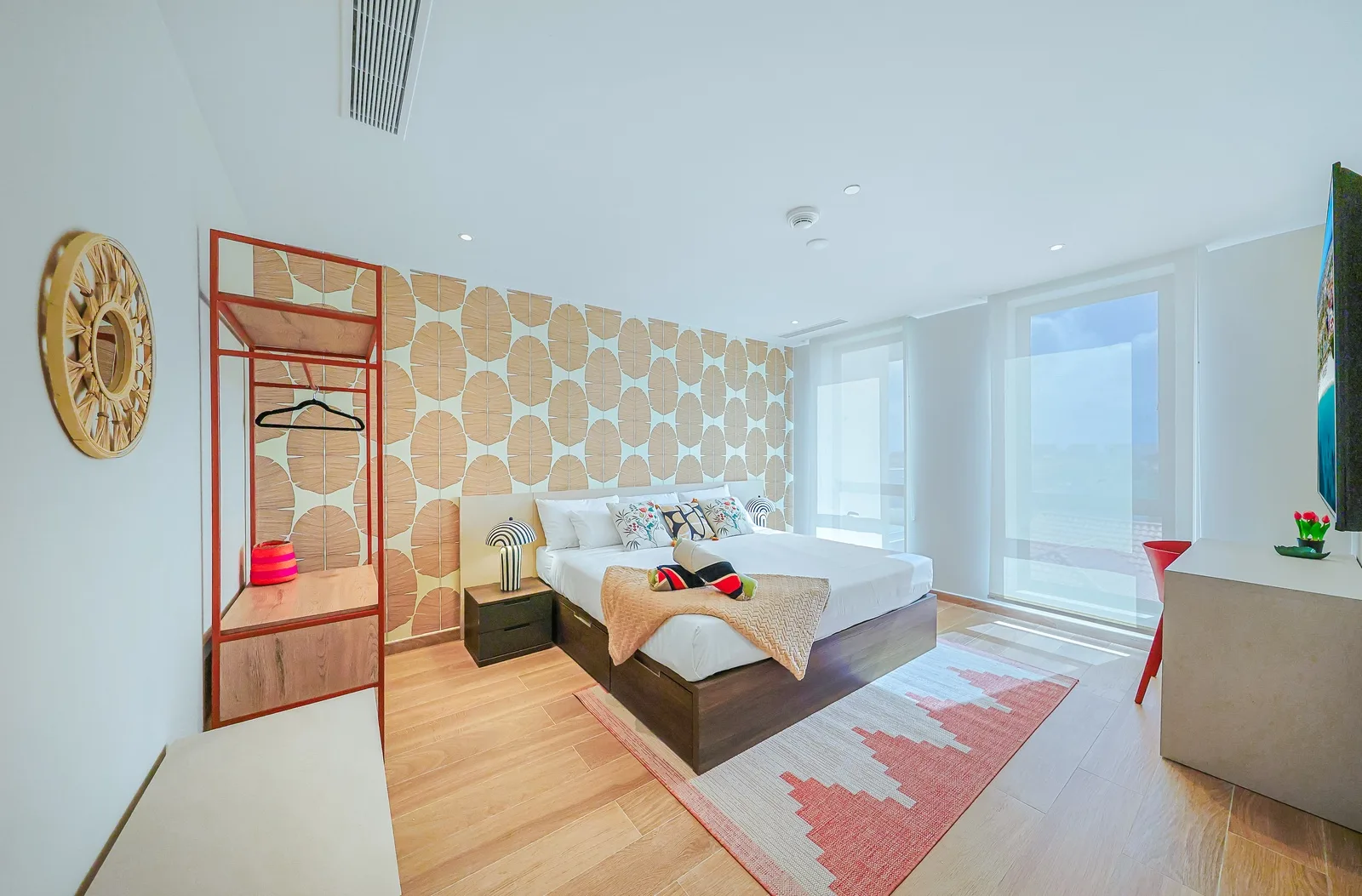 Settle into your modern bedroom featuring a plush king size bed and a stylish wooden room divider with convenient hanging space. A comfortable and inviting retreat designed for relaxation.