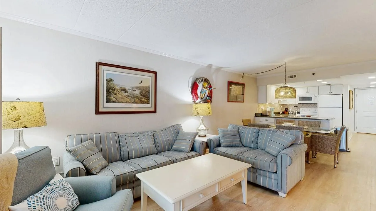 A living room with blue seating and a white coffee table.