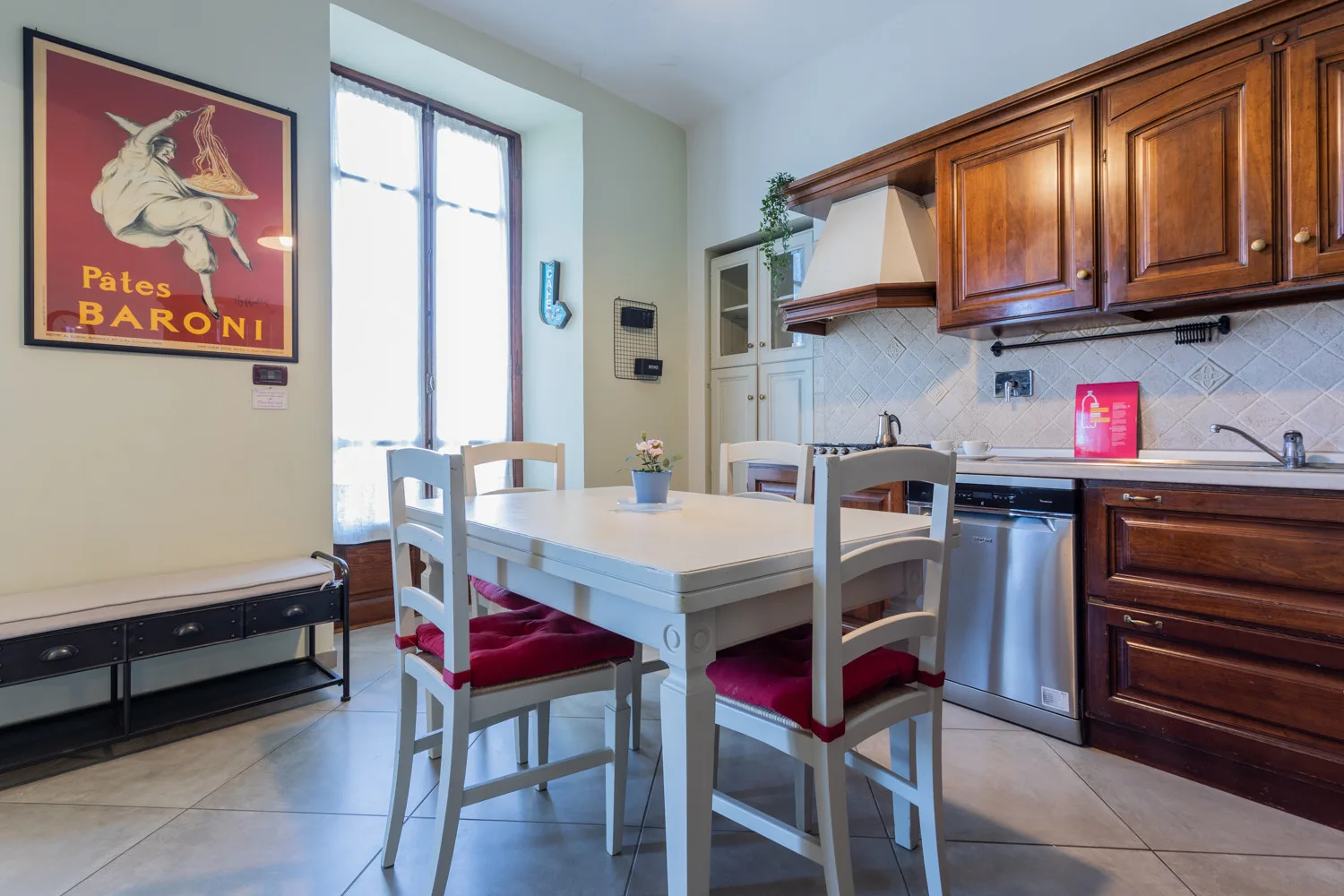A bright kitchen and dining area with a white table beside wooden cabinets.