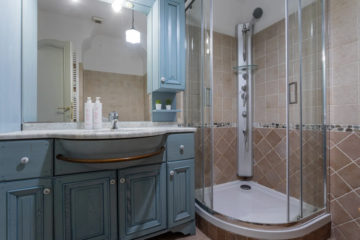 A bathroom with a vanity and a glass shower.
