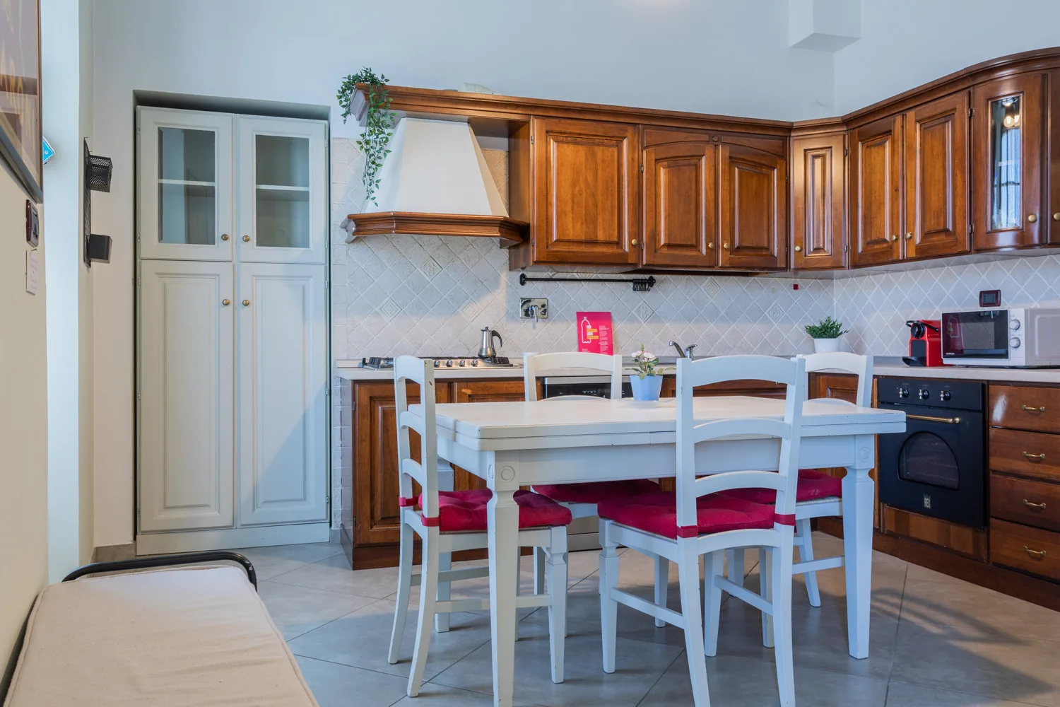 A kitchen with wooden cabinets and a dining table surrounded by chairs.