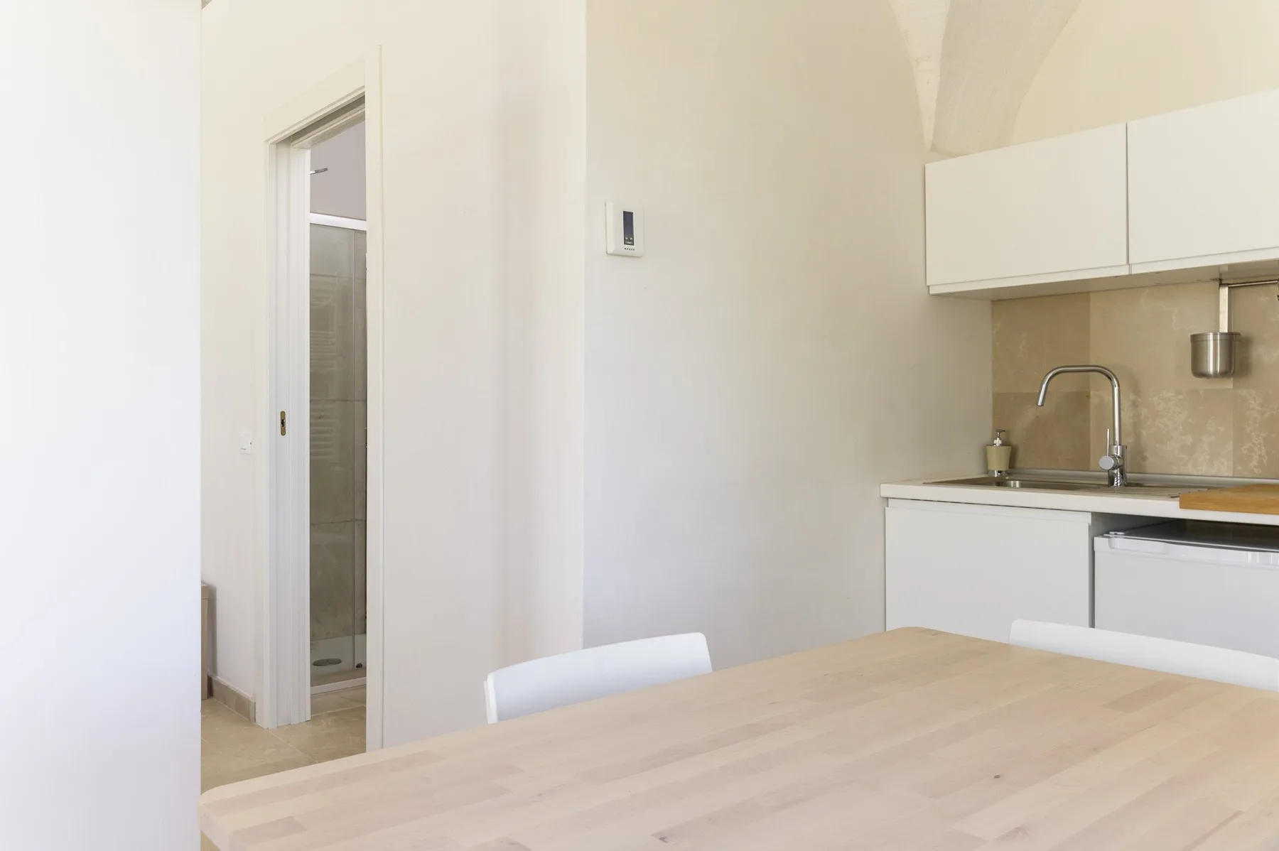 A bright kitchen and dining area with a table and sink.