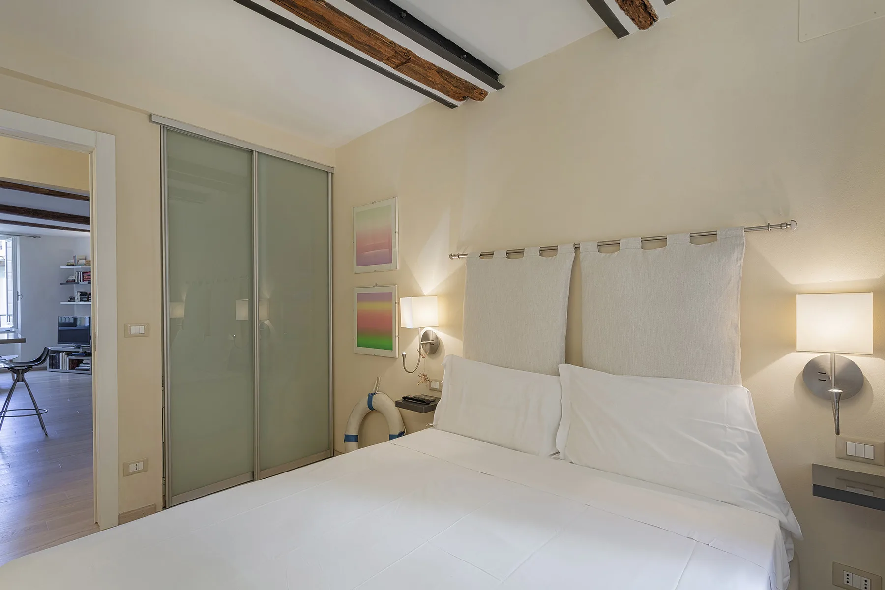 Un dormitorio con una cama bien hecha y puertas corredizas de armario.