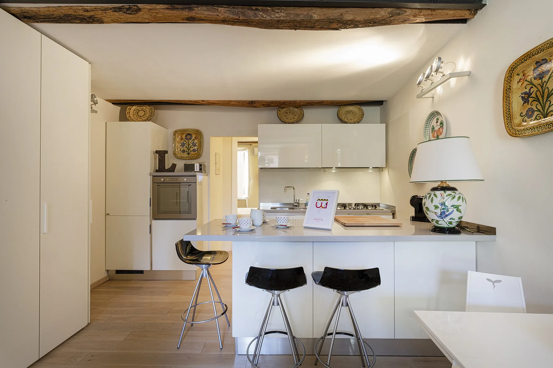 Una cocina luminosa con una barra de desayuno y asientos.