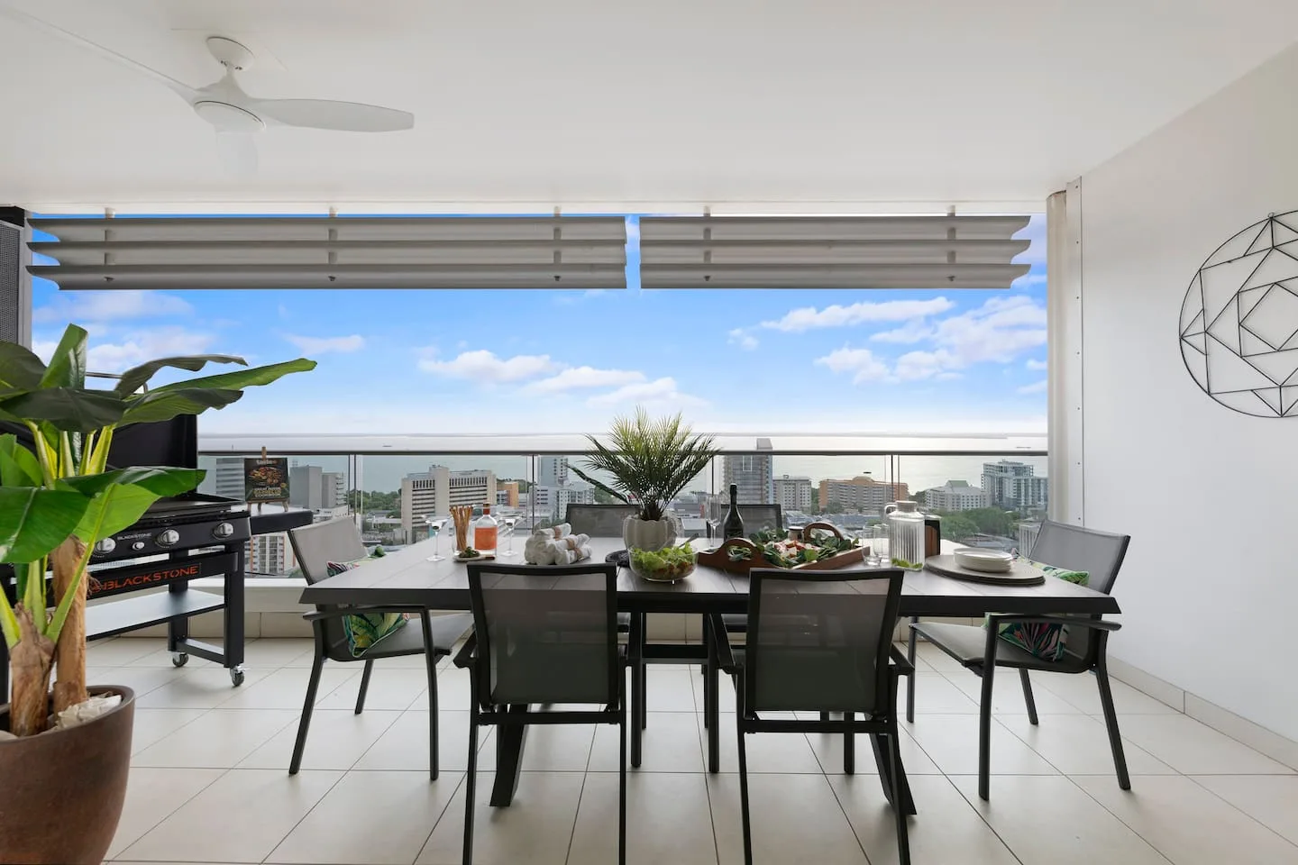 An outdoor dining area with a table and seating overlooking nearby buildings.