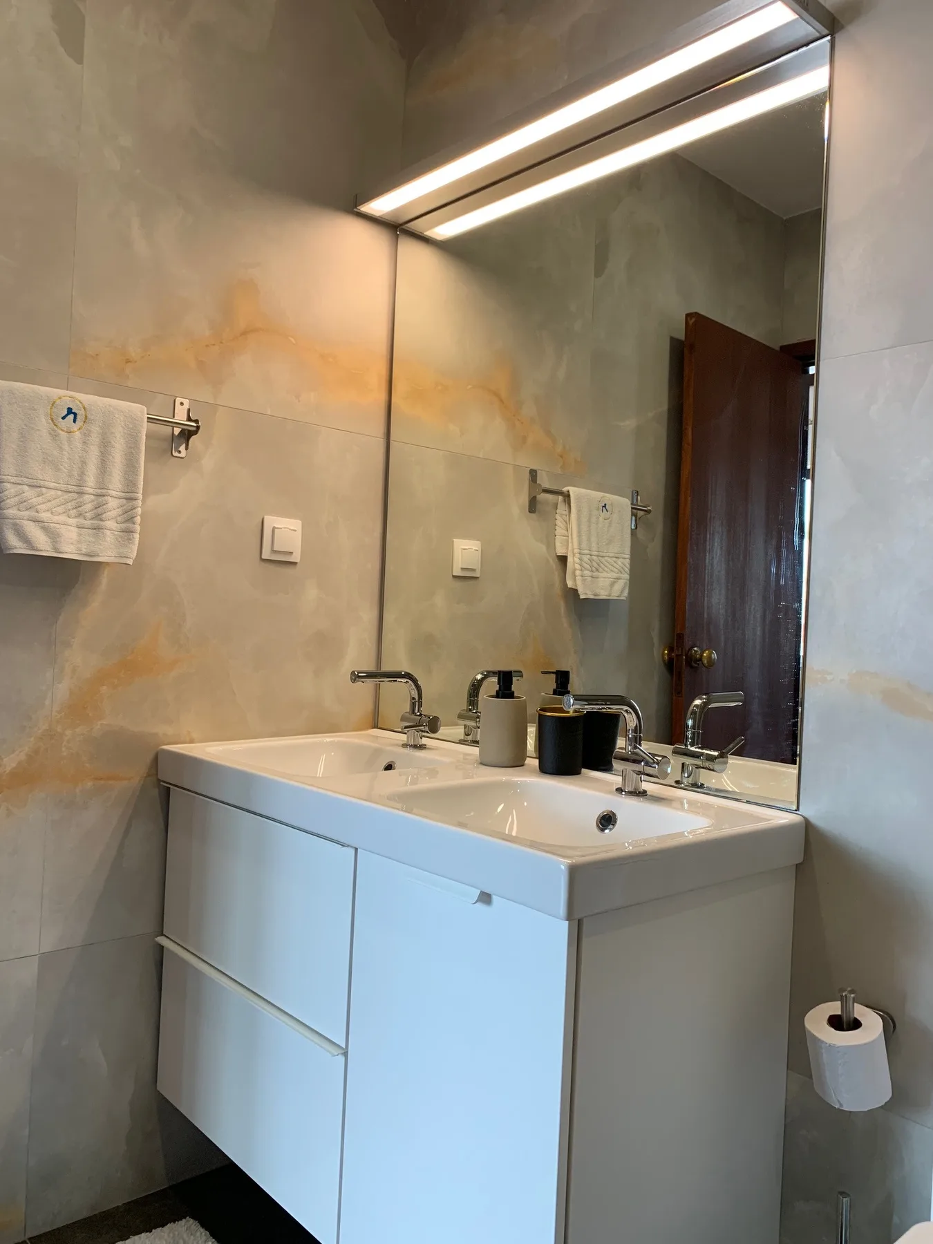 Un baño con un lavabo y un espejo grande.