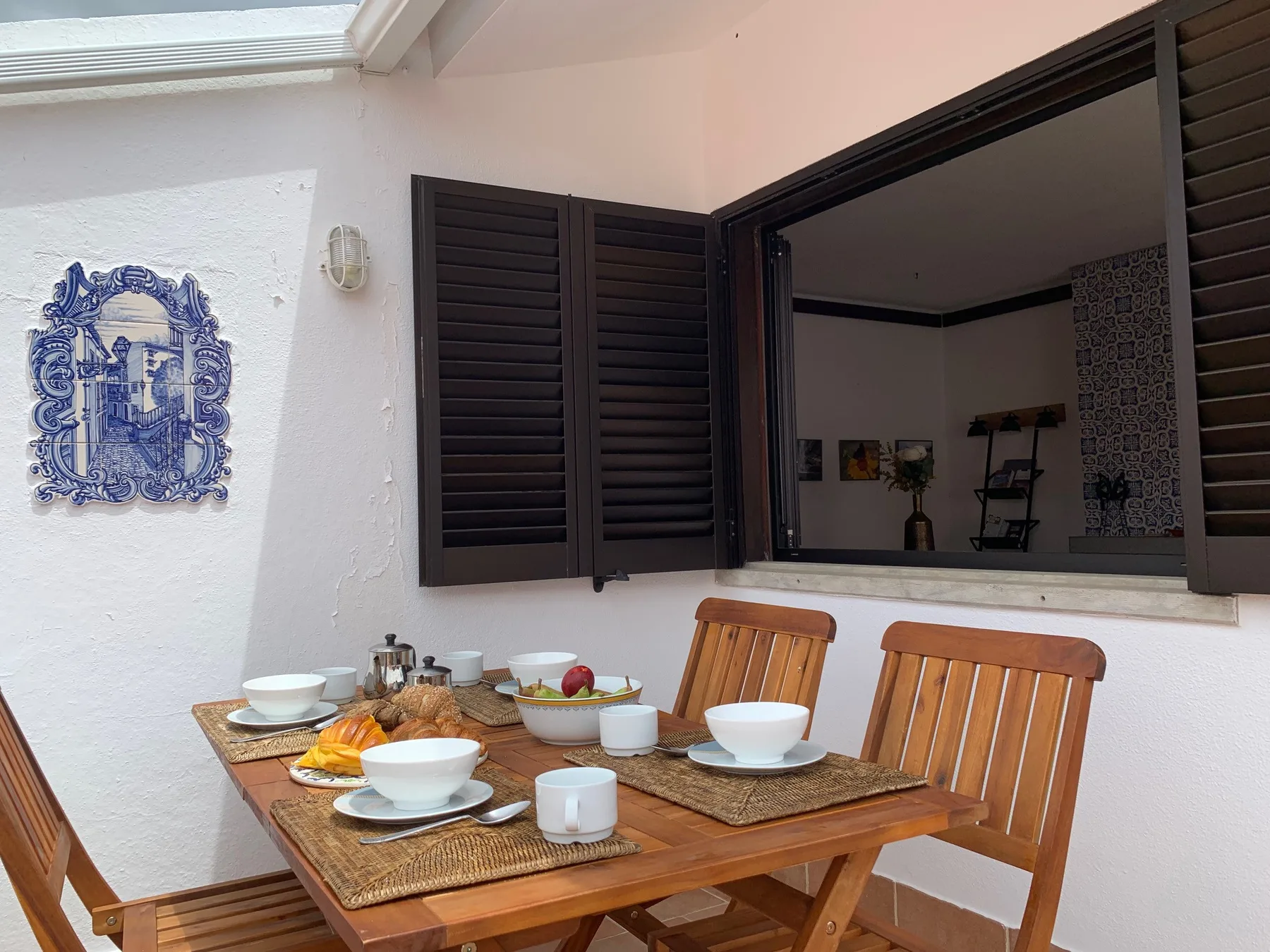 Comedor con una mesa de madera preparada con platos y tazas.
