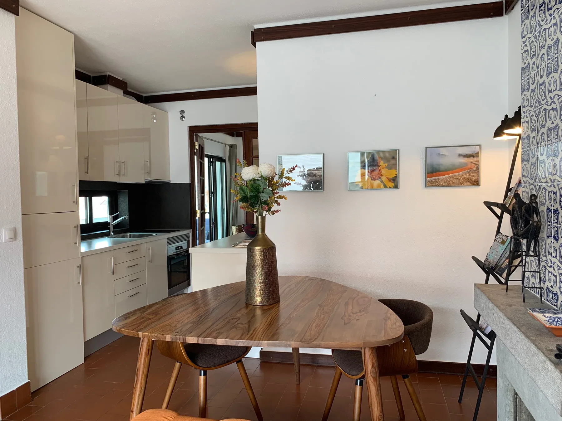 Un comedor con una mesa de madera junto a una cocina compacta.