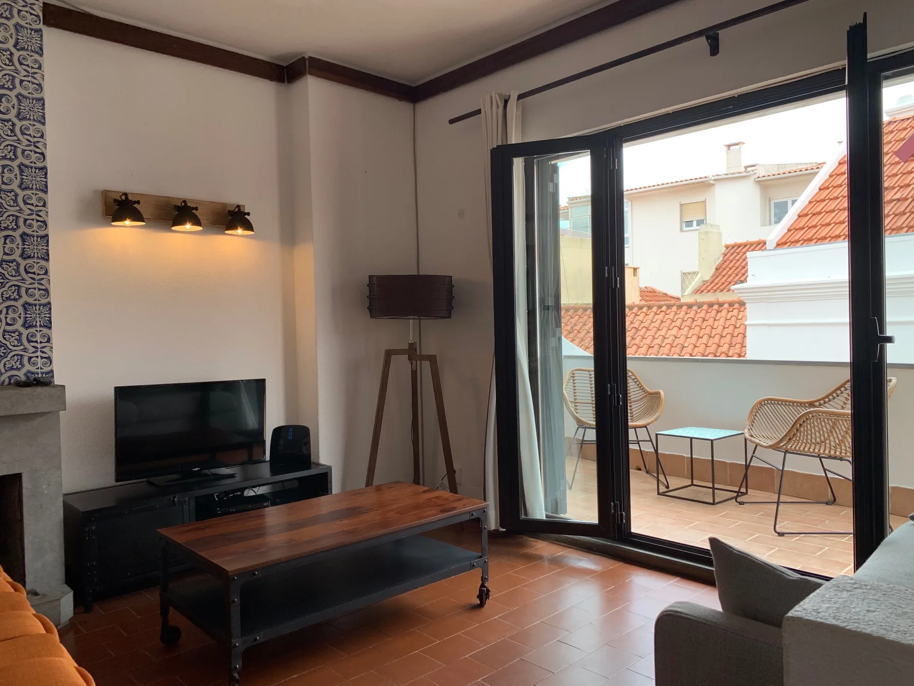 Una sala de estar se abre a una terraza con asientos y una mesa baja.