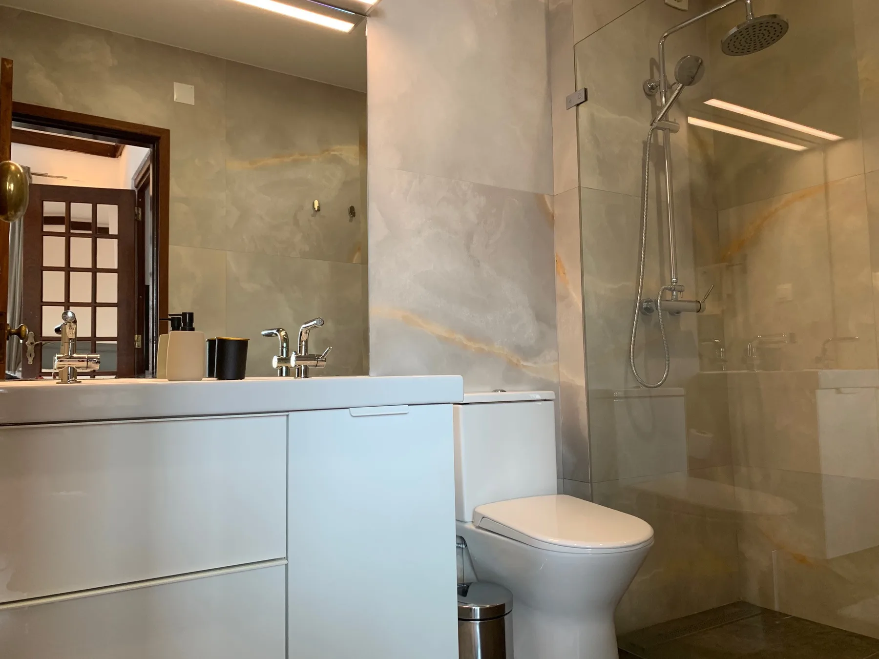 Un baño con lavabo, inodoro y ducha de vidrio.