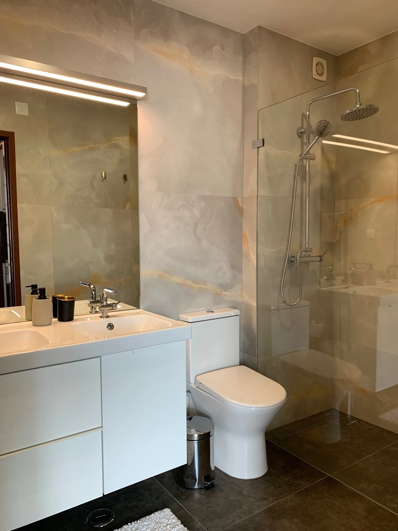 Un baño con lavabo, inodoro y ducha de vidrio.