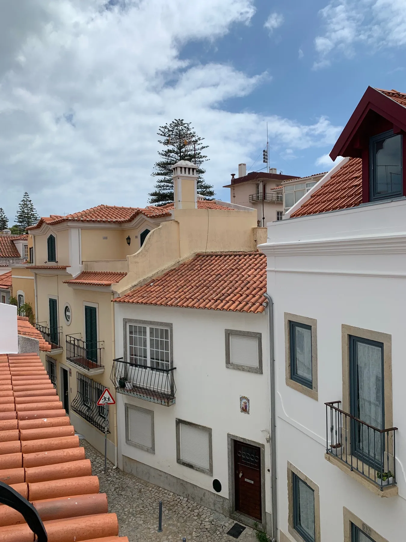 Vista de edificios muy próximos con tejados de tejas rojizas bajo un cielo nublado.